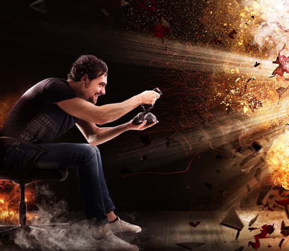 Gamer alla console con joy pad circondato da un'effetto di esplosione
