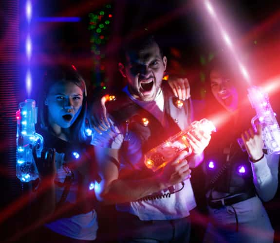 Ritratto di gruppo di giovani con fasci colorati di pistole laser